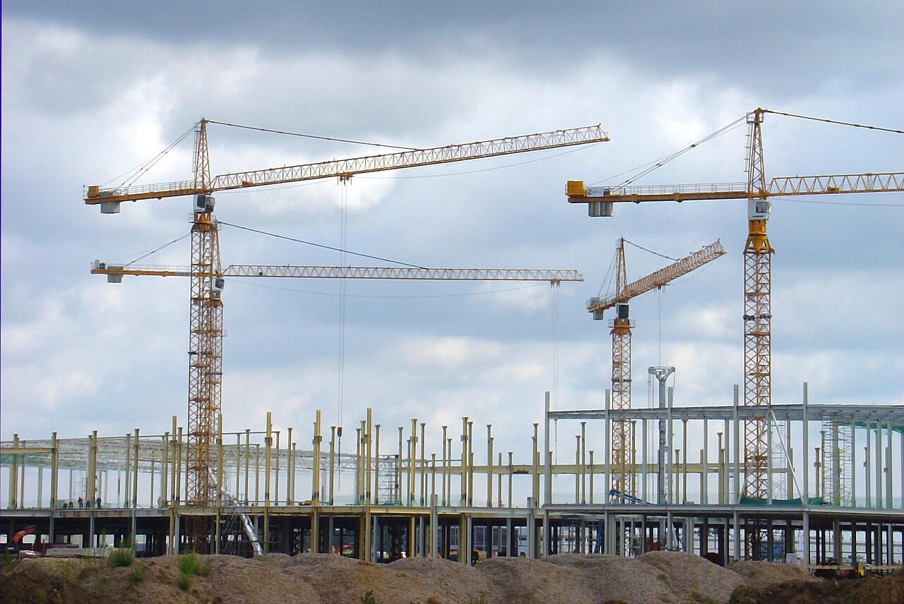 A row of tower cranes over a large construction project