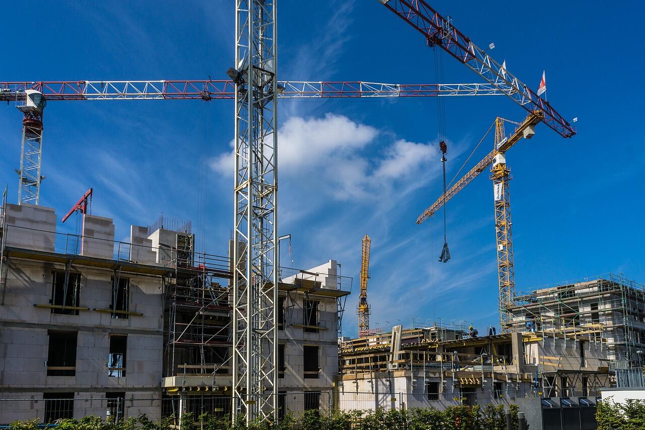 Cranes above the concrete frame of a building under construction