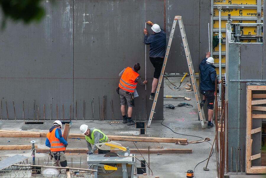 A crew working along a formed concrete wall