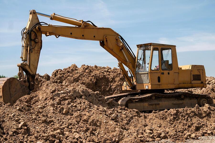 An excavator working a pile of earth